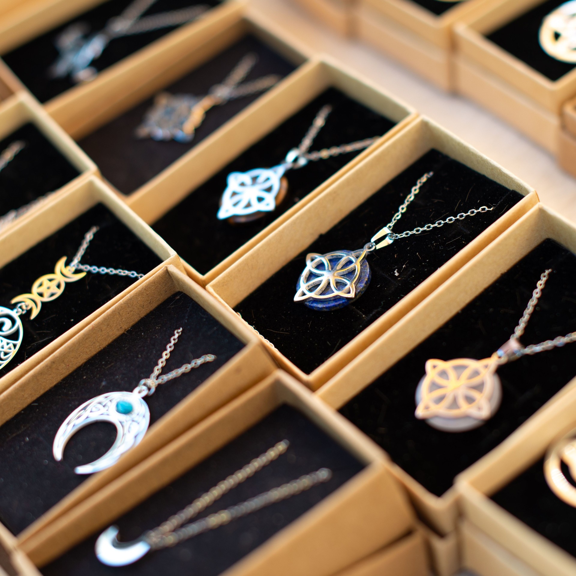 Intricate silver necklaces displayed in boxes.